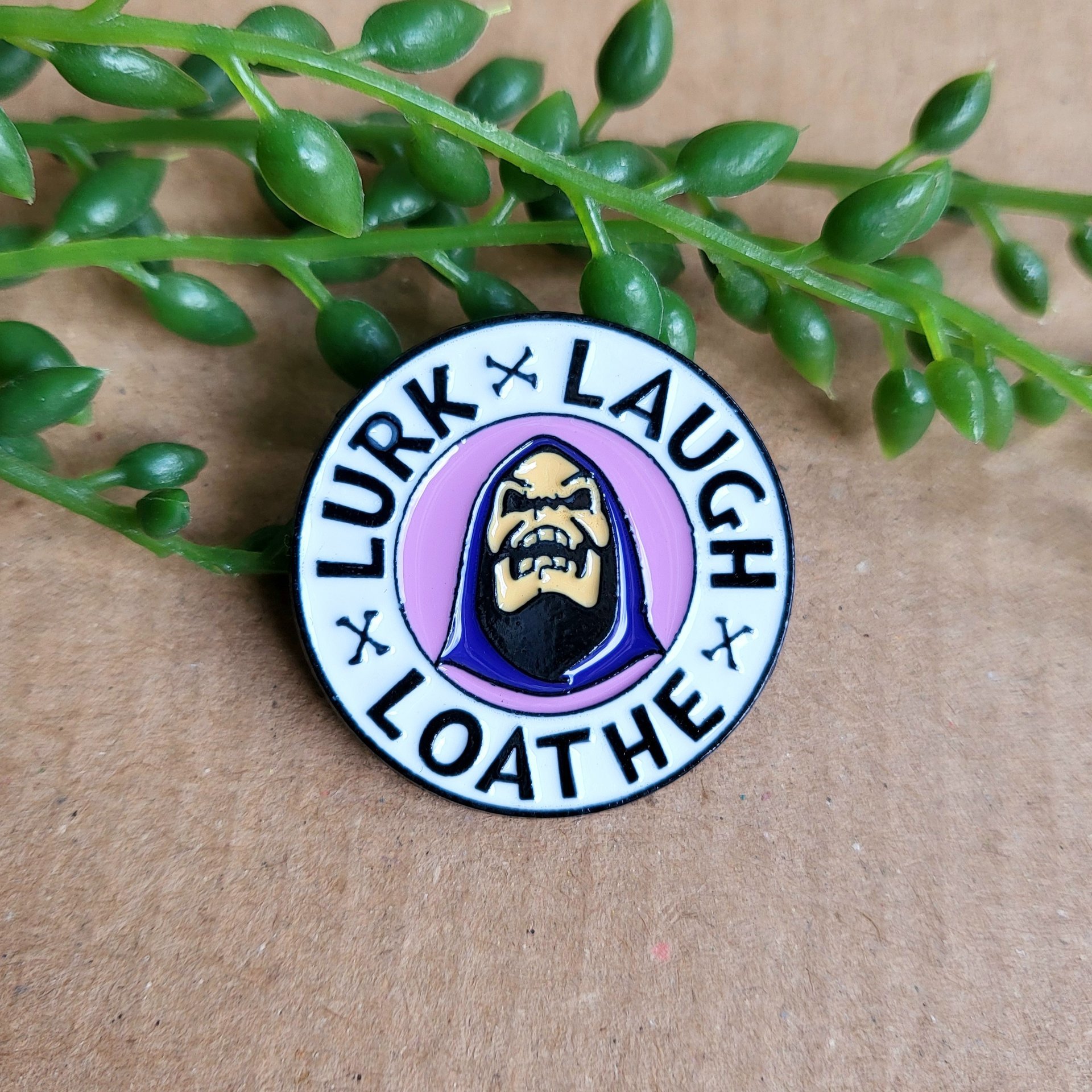 skeletor enamel pin badge, with the text lurk, laugh and loathe. Masters of the universe enamel pin badge.