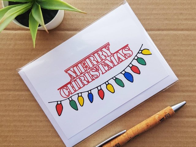 Stranger Things Christmas card, front reads Merry Christmas in Stranger things font with Stranger things lights